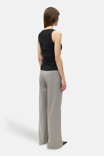 Haut noir d'ENVII, vu de dos, combiné avec un pantalon ample gris et des chaussures noires.