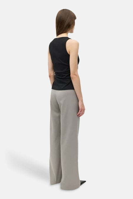 Haut noir d'ENVII, vu de dos, combiné avec un pantalon ample gris et des chaussures noires.