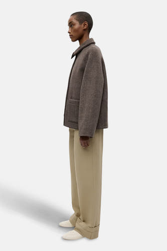 Veste courte brune d'ENVII, avec une longue jupe beige et des chaussures blanches, en vue de côté.