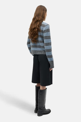 Grijs gilet van ENVII, met een gestreept patroon en gecombineerd met zwarte culotte en zwarte leren laarzen.