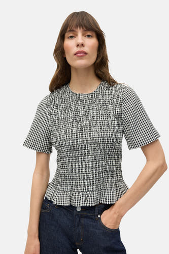 Blouse à manches courtes en motif à carreaux blancs d'ENVII, avec smockage et manches courtes, associée à des jeans foncés.