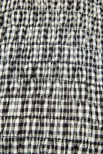 Blouse blanche en coton d'ENVII avec des manches courtes, une texture rayée noir et blanc et des détails élastiques.
