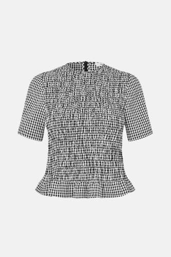 Blouse blanche à manches courtes d'ENVII, avec smockage et imprimé rayé noir et blanc.