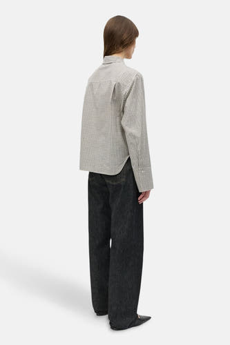 Chemise beige à longues manches d'ENVII, avec un petit motif rayé, portée avec des jeans foncés.