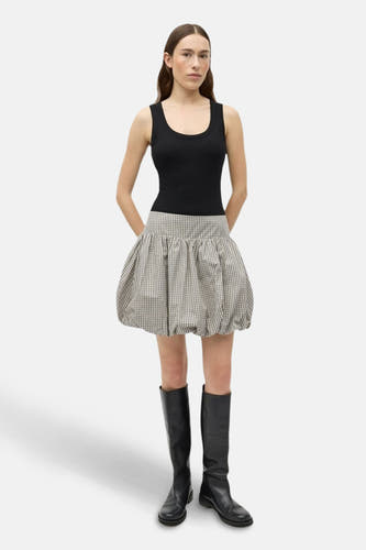 Robe courte beige d'ENVII avec une imprimé fluide, portée avec un tanktop noir et des bottes.