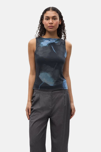 T-shirt sans manches noir d'ENVII, avec des motifs floraux bleus, associé à un pantalon gris rayé et des chaussures noires.