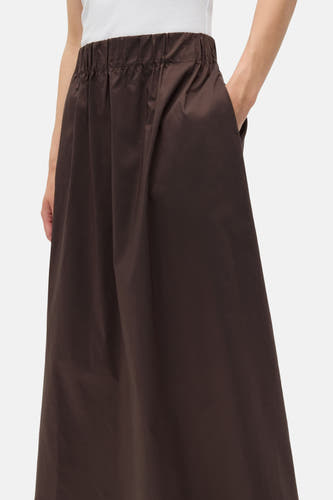 Jupe brune d'ENVII, avec une ceinture élastique et une main dans la poche.