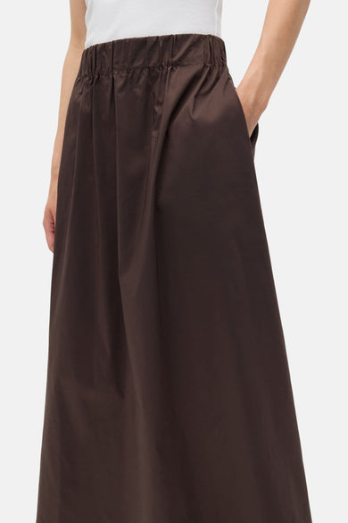 Jupe brune d'ENVII, avec une ceinture élastique et une main dans la poche.