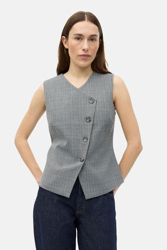 Grijze blazer van ENVII, met asymmetrische knoopsluiting en subtiele verticale strepen. Gedragen met een donkere jeans.