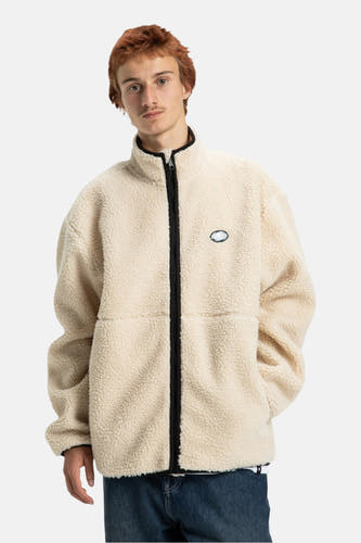 Manteau court beige de DC SHOES avec fermeture éclair noire et anneau doré.