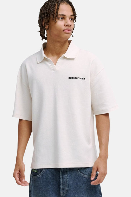 Polo oversize blanche de DC SHOES avec texture légère, vue arrière. Modèle avec tresses et jean.
