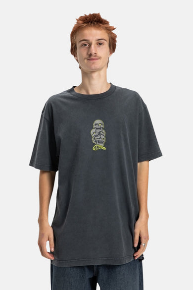 T-shirt gris à manches courtes de DC SHOES, avec des têtes de mort et des manches courtes, porté avec un jean.