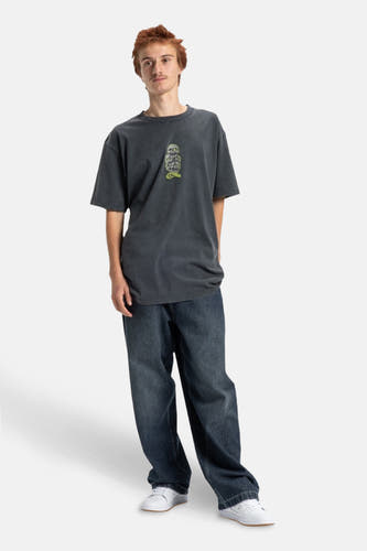 T-shirt gris à manches courtes de DC SHOES, avec un imprimé sur la poitrine, porté avec des jeans décontractés et des baskets blanches.