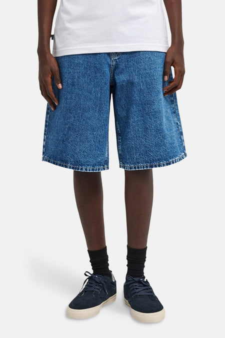 Short en jean ELEMENT, en denim bleu moyen, avec poches arrière et combiné avec des chaussettes noires et des chaussures bleues.