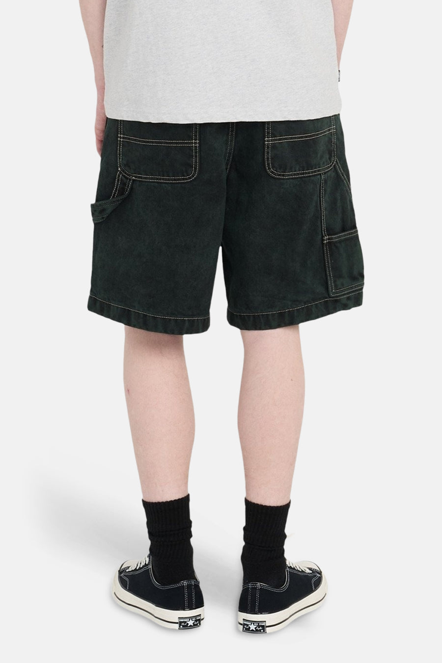 Groene jeansshort van ELEMENT met gereedschapzakken, gecombineerd met zwarte sokken en lage schoenen.