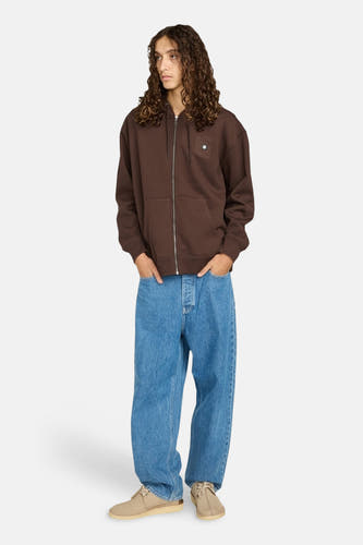 Pull marron d'ELEMENT, avec des manches longues, une fermeture éclair et des poches, associé à des jeans larges et des chaussures en cuir de mouton.