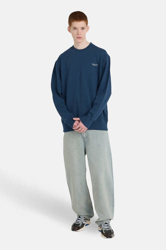 Pull-over bleu d'ELEMENT, avec une coupe décontractée, associé à des jeans larges et des baskets.