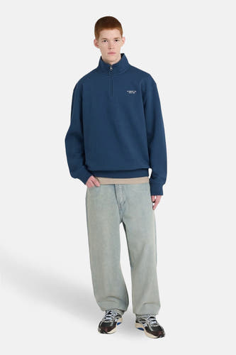 Pull-over bleu d'ELEMENT, avec une fermeture éclair courte et des jeans décontractés et des baskets.