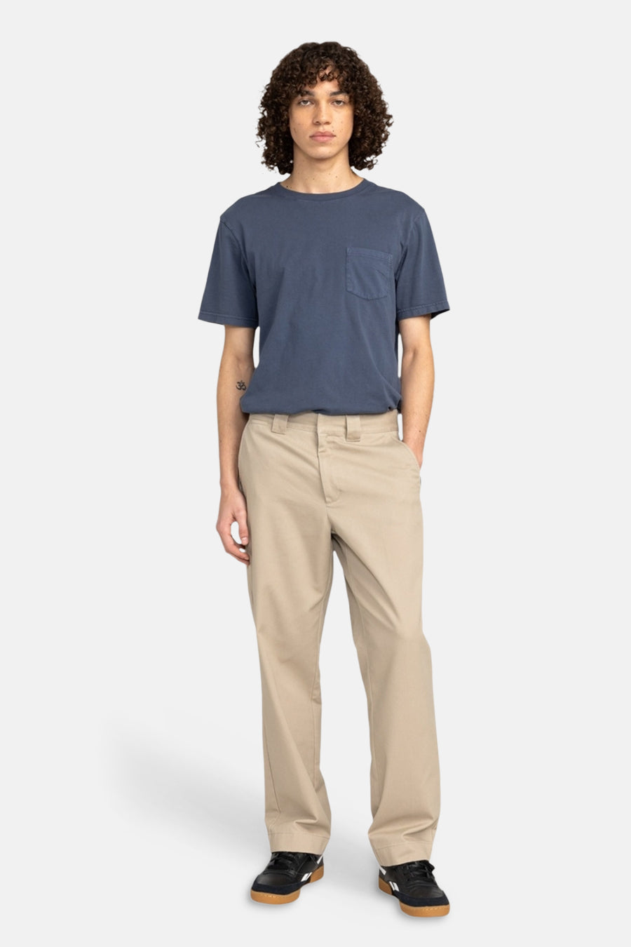 Chino beige d'Element, porté avec un t-shirt bleu et des baskets noires.