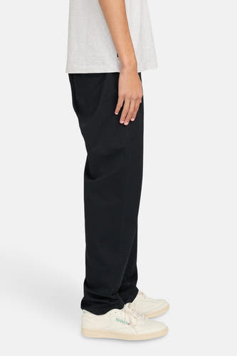 Chino noir d'ELEMENT, vu de côté, associé à un t-shirt gris et des chaussures crème.