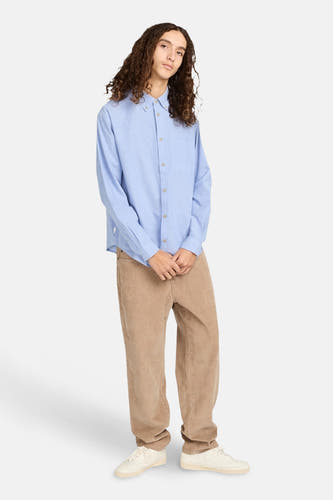 Pantalon beige d'ELEMENT, associé à une chemise bleu clair et des baskets blanches.