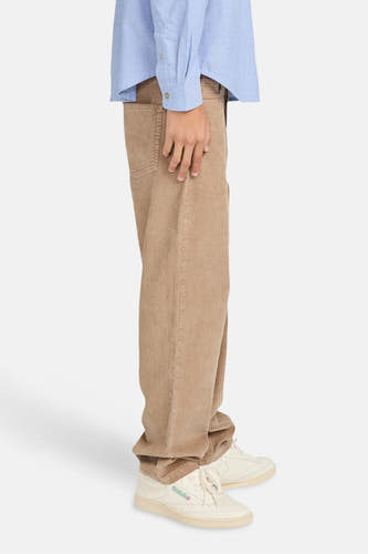 Beige broek van ELEMENT, met wijde pijpen en lichtgekleurde schoenen.
