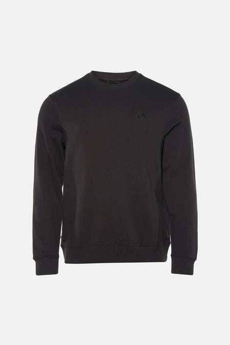 Pull noir ELEMENT, à manches longues, combiné avec un jean déchiré et des baskets beiges.
