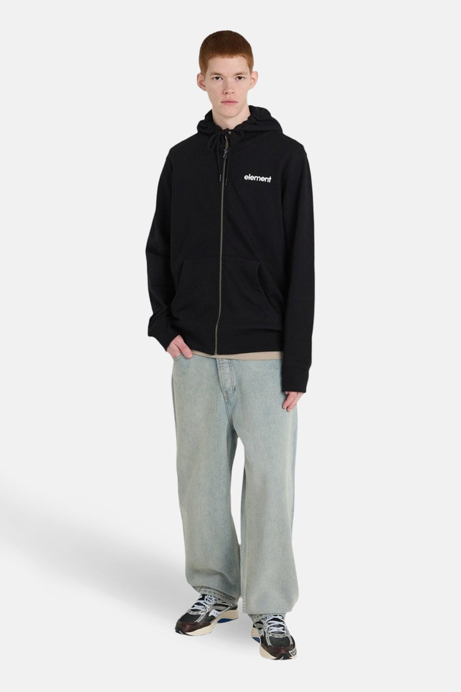 Pull noir et gilet d'ELEMENT, avec capuche et fermeture éclair, porté avec des jeans larges et des baskets.