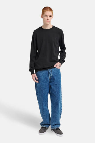 Pull noir à col rond d'ELEMENT, avec des manches longues, porté avec un short en denim bleu et des chaussures grises.