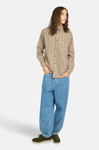 Chemise beige à manches longues d'ELEMENT, avec un motif à carreaux et portée avec des jeans larges.