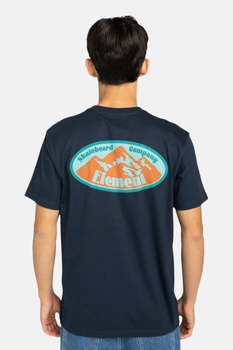 Achterkant van een man in een donkerblauw T-shirt met een berglandschaplogo.
