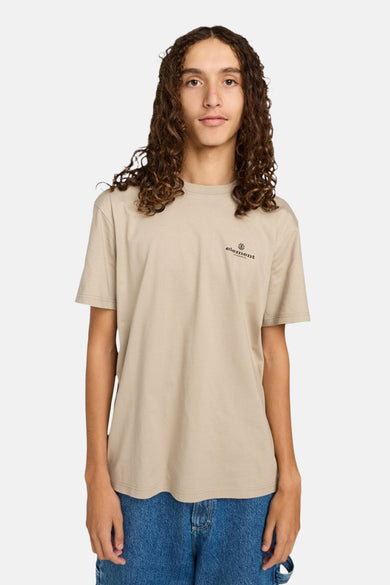 T-shirt beige à manches courtes d'ELEMENT, avec un petit logo sur la poitrine, porté avec des jeans bleus.
