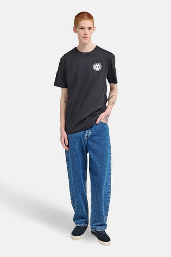 T-shirt noir à manches courtes d'ELEMENT, avec un logo sur la poitrine, porté avec des jeans bleus.
