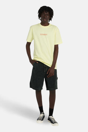 T-shirt jaune à manches courtes de ELEMENT, porté avec un short en jean foncé, des chaussettes noires et des baskets en toile.
