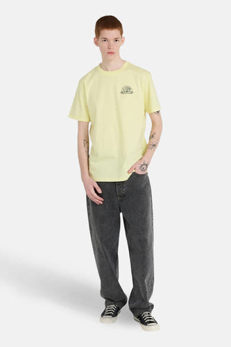 T-shirt jaune à manches courtes de ELEMENT, avec un petit imprimé sur la poitrine, combiné avec un jean gris et des baskets.
