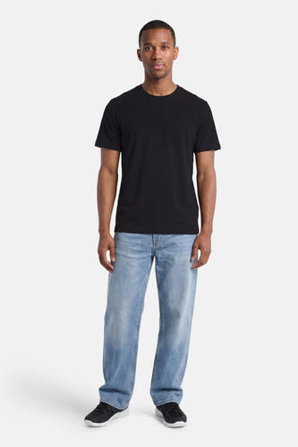 T-shirt noir d'ELEMENT avec logo discret sur la poitrine, porté par un homme avec un jean clair et des baskets noires.