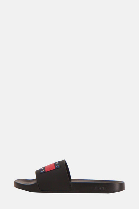 Chaussons noirs Tommy Jeans avec logo sur la semelle en couleurs rouge, blanc et bleu.