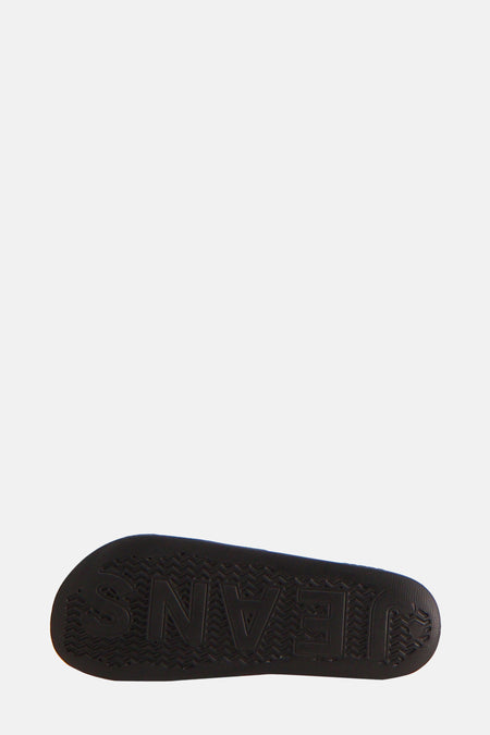 Chaussons noirs de TOMMY JEANS avec une impression textuelle en relief sur la semelle.