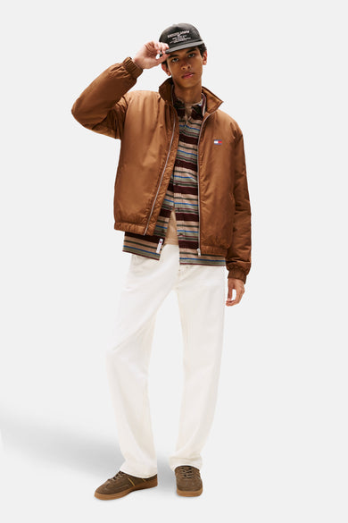 Sneakers vertes Tommy Tommy, avec des détails etine et des lacets, associés à des jeans blancs et une veste marron.