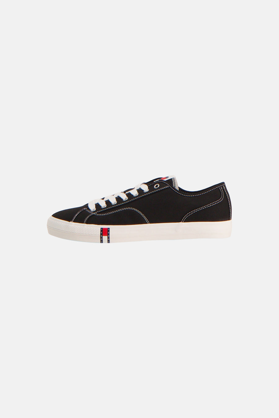 Baskets noires de TOMMY JEANS, avec lacets et semelle blancs, et logo sur le côté.