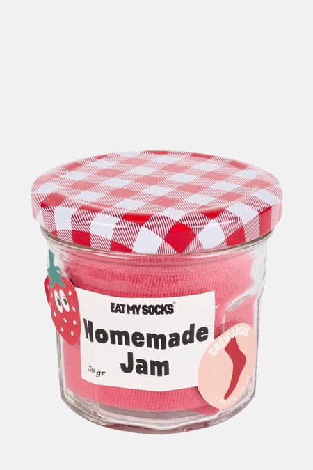 Chaussettes roses d'EAT MY SOCKS, emballées dans un pot avec un couvercle en forme de raisin et une étiquette fraise.