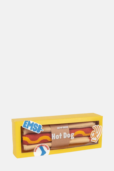 Chaussettes multicolores d'EAT MY SOCKS, présentées comme un hotdog dans une boîte jaune.