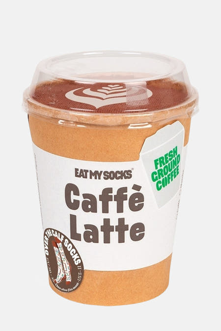 Chaussettes multicolores d'EAT MY SOCKS, dans une tasse à café avec l'inscription "Caffè Latte" et un motif de mousse décoratif.