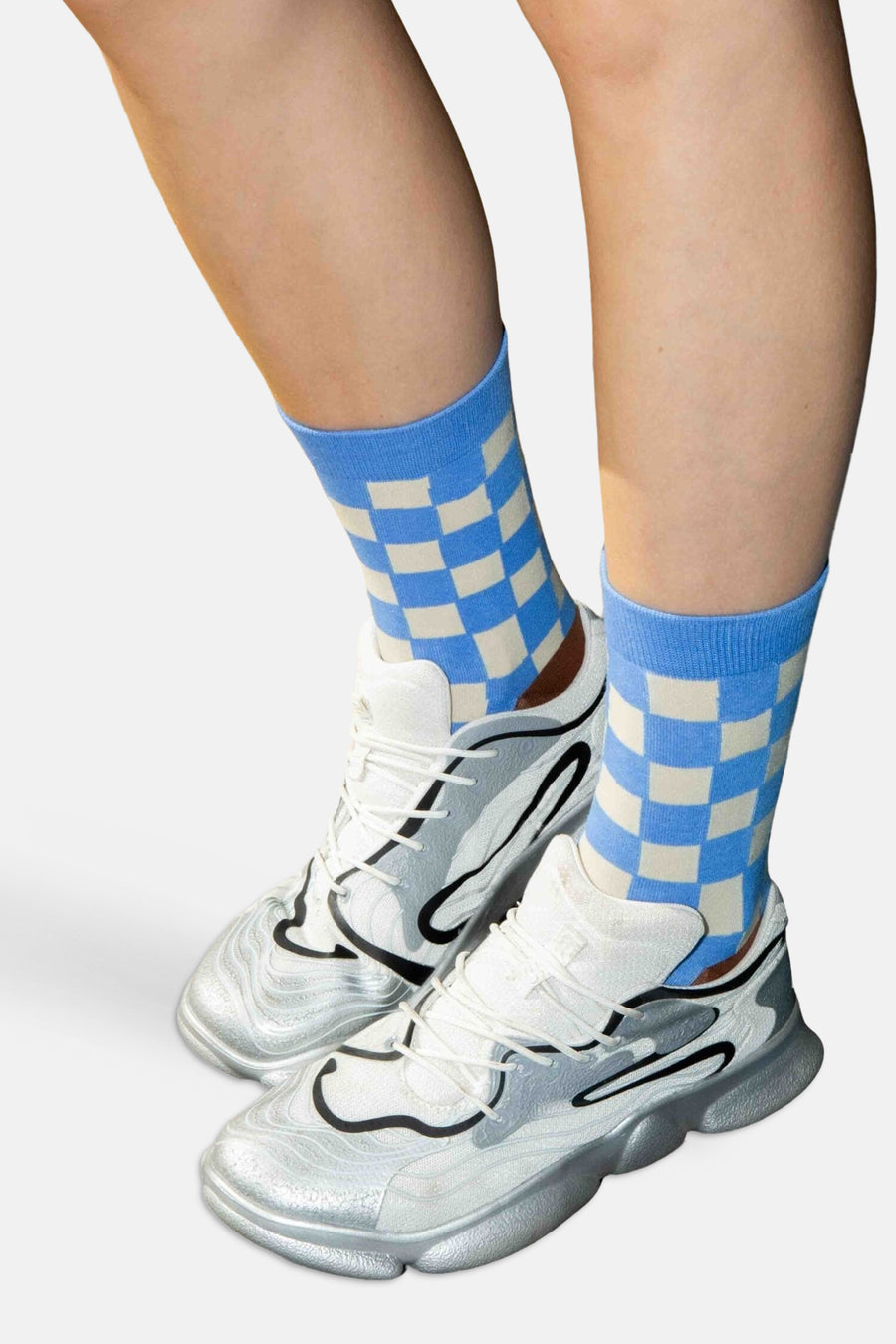 Multicolor toilettas van EAT MY SOCKS, blauw-wit geruit, gedragen met zilveren sneakers, vooraanzicht