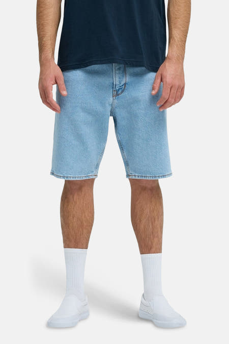 Short en jean bleu clair Quiksilver, vu de dos, avec des chaussettes et des chaussures blanches.