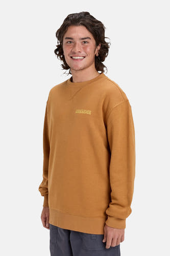 Pull-over orange avec col rond de Quiksilver, avec logo sur la poitrine et pantalon gris.