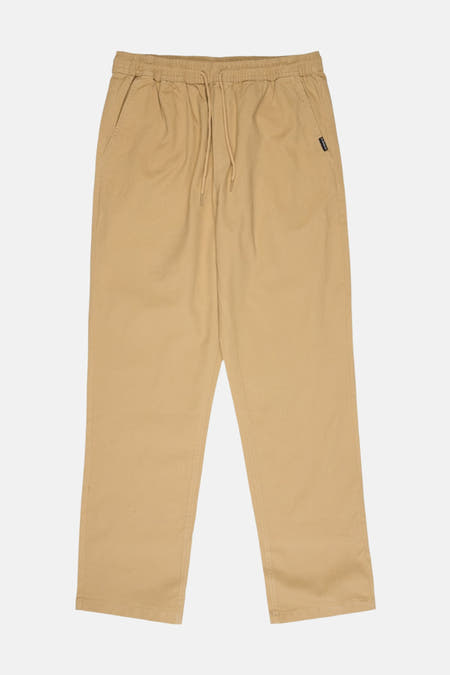 Pantalon beige Quiksilver, avec une taille élastique et un cordon de serrage.