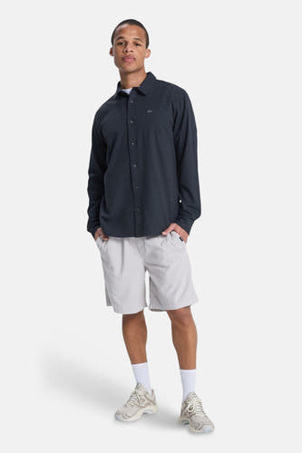 Short gris de Quiksilver, porté avec une chemise à manches longues, des chaussettes et des baskets.