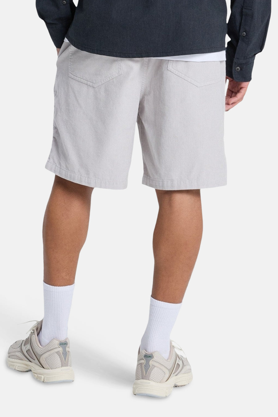 Short gris de Quiksilver, avec texture côtelée verticale, vu de dos, combiné avec des chaussettes blanches et des baskets.