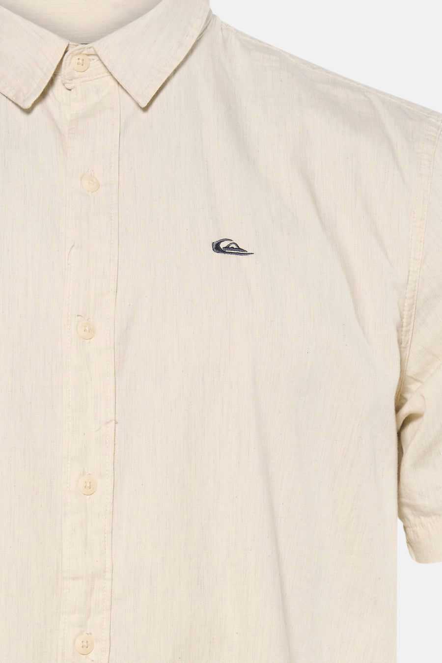 Chemise écru à manches courtes de Quiksilver, avec logo discret sur la poitrine et fermeture boutonnée.